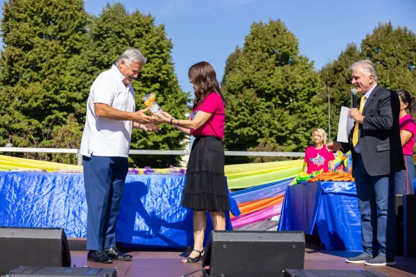 La consegna di un premio sul palco, tra una stretta di mano e un sorriso.